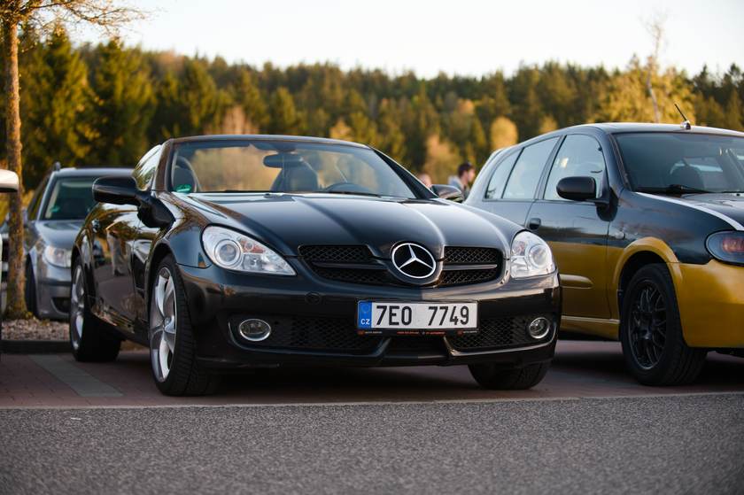 Černý kabriolet Mercedes SLK zaparkovaný na lesní cestě