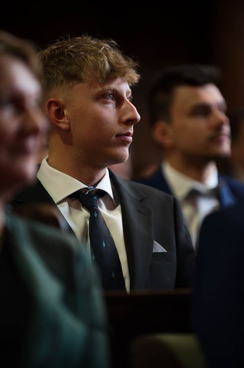 Dva maturanti v oblecích sledují průběh ceremoniálu